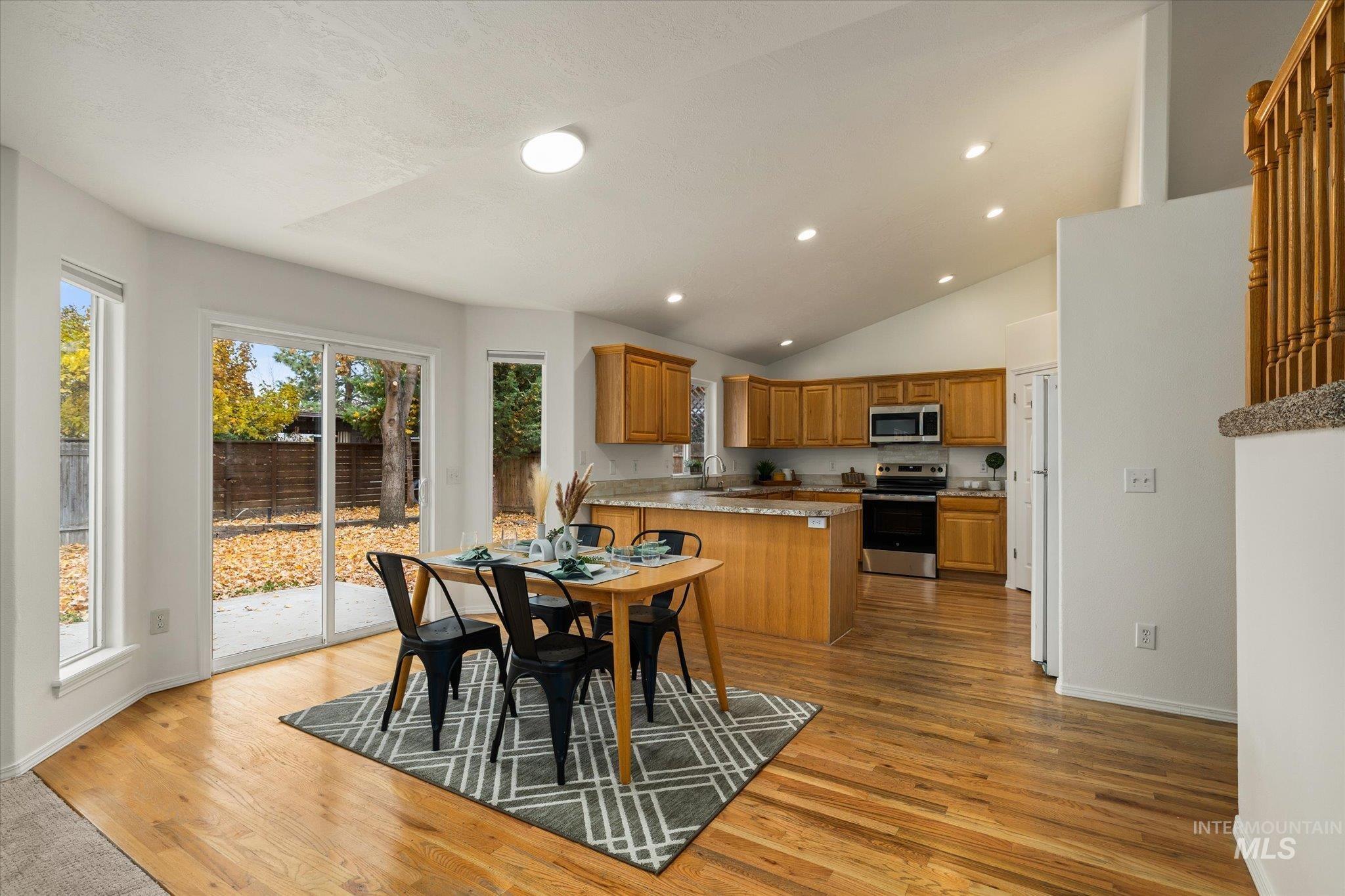 Dining area with light wood-style floors, recessed lighting, and lofted ceiling