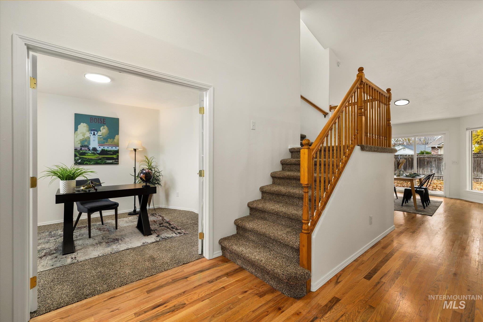 Staircase with wood finished floors and recessed lighting