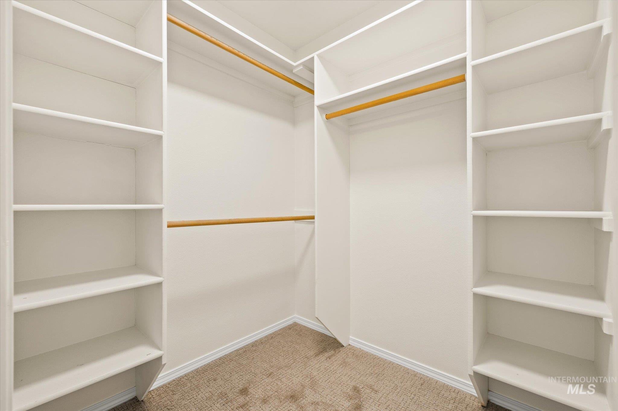 Spacious closet with light colored carpet