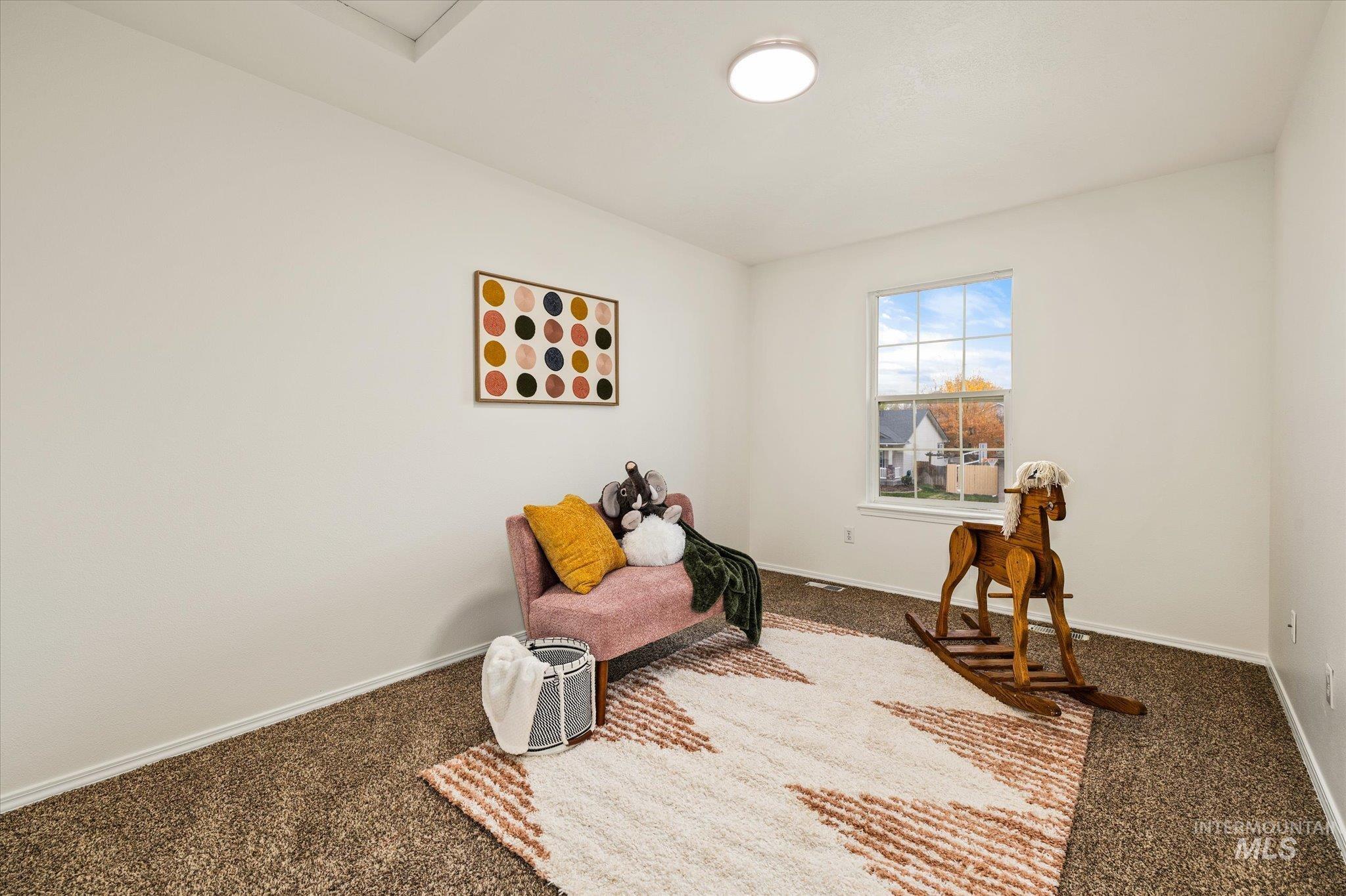 Living area featuring carpet flooring and baseboards