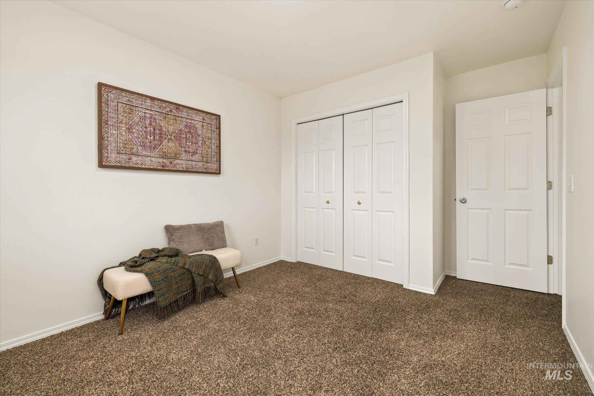 Living area with dark carpet and baseboards