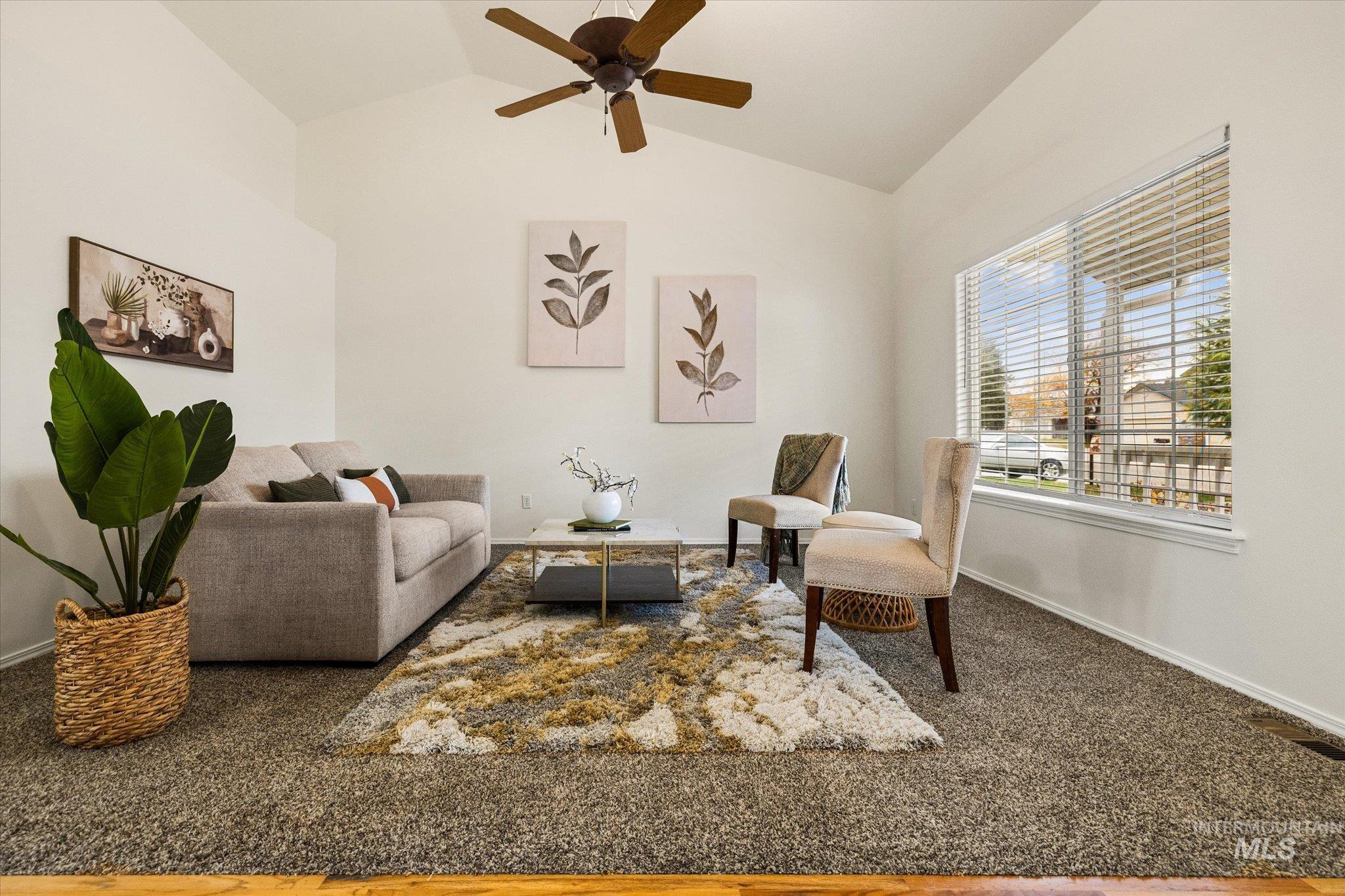 Living room featuring a ceiling fan, wood finished floors, and high vaulted ceiling