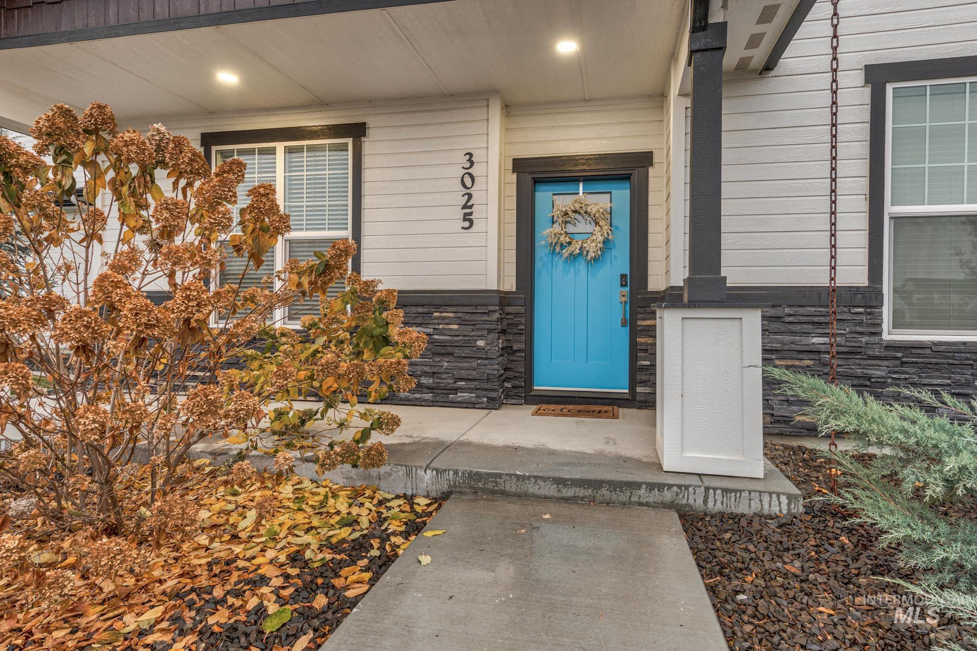 Entrance to property with stone siding and a porch