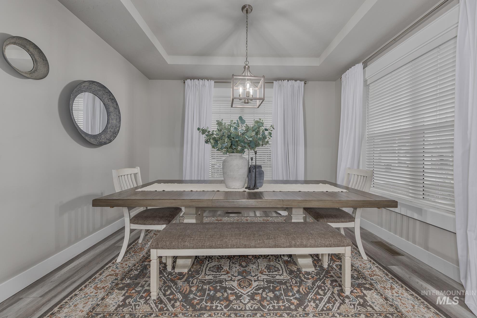 Dining area with a raised ceiling and wood finished floors