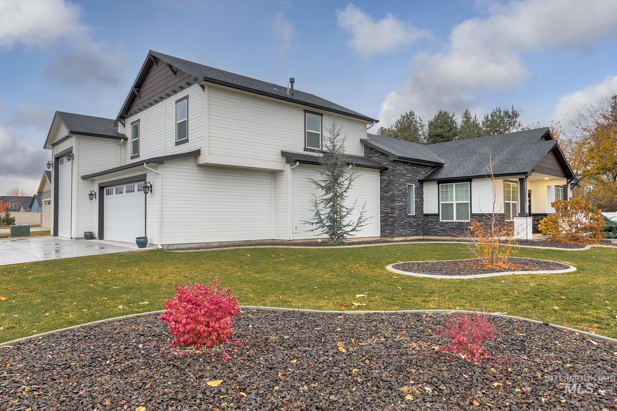 View of front of house featuring a front lawn, driveway, and an attached garage
