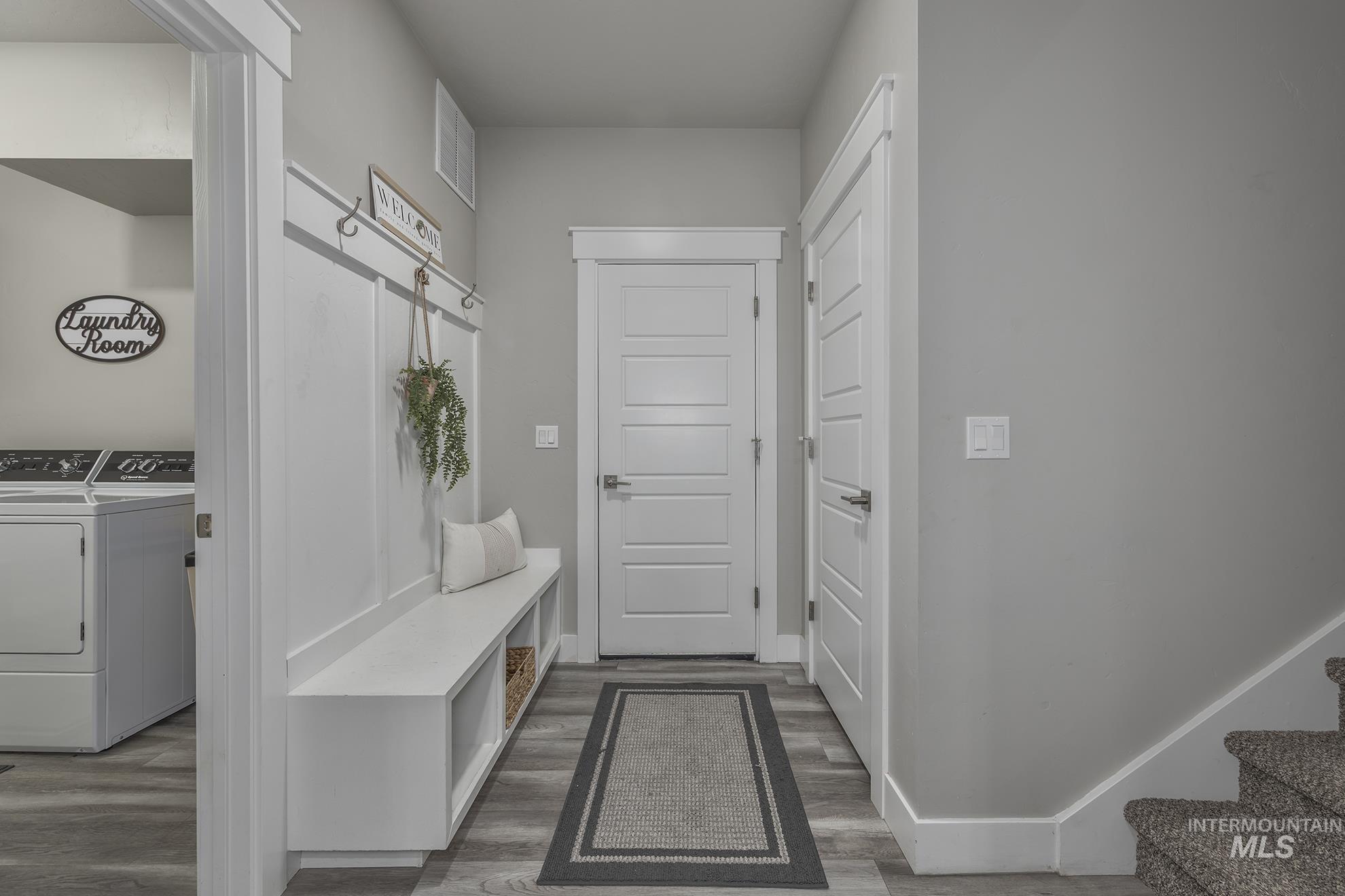 Mudroom with wood finished floors and washer and dryer