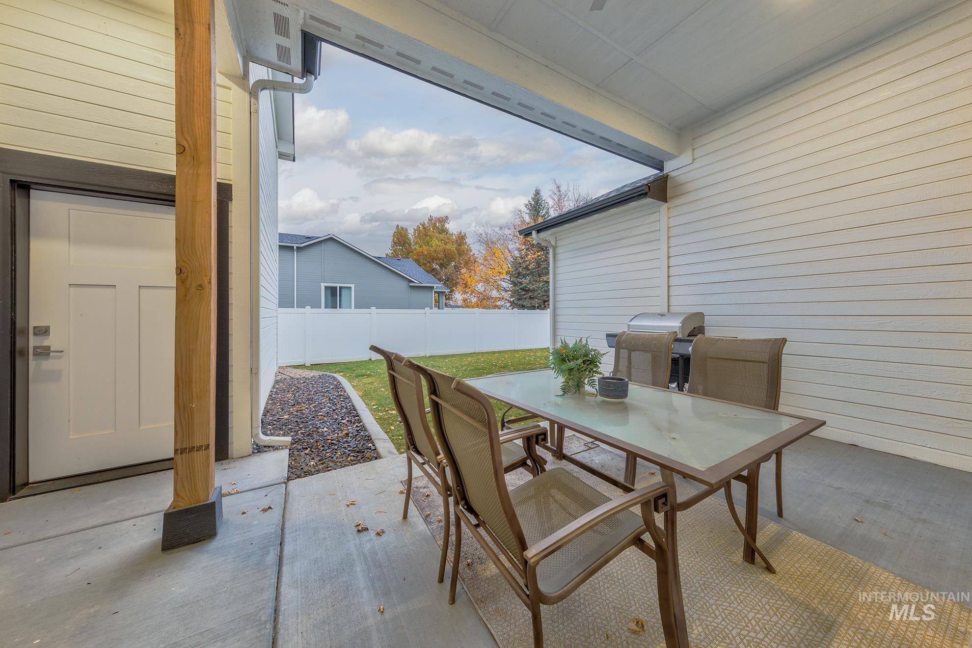 Fenced backyard with outdoor dining space, a patio, and grilling area