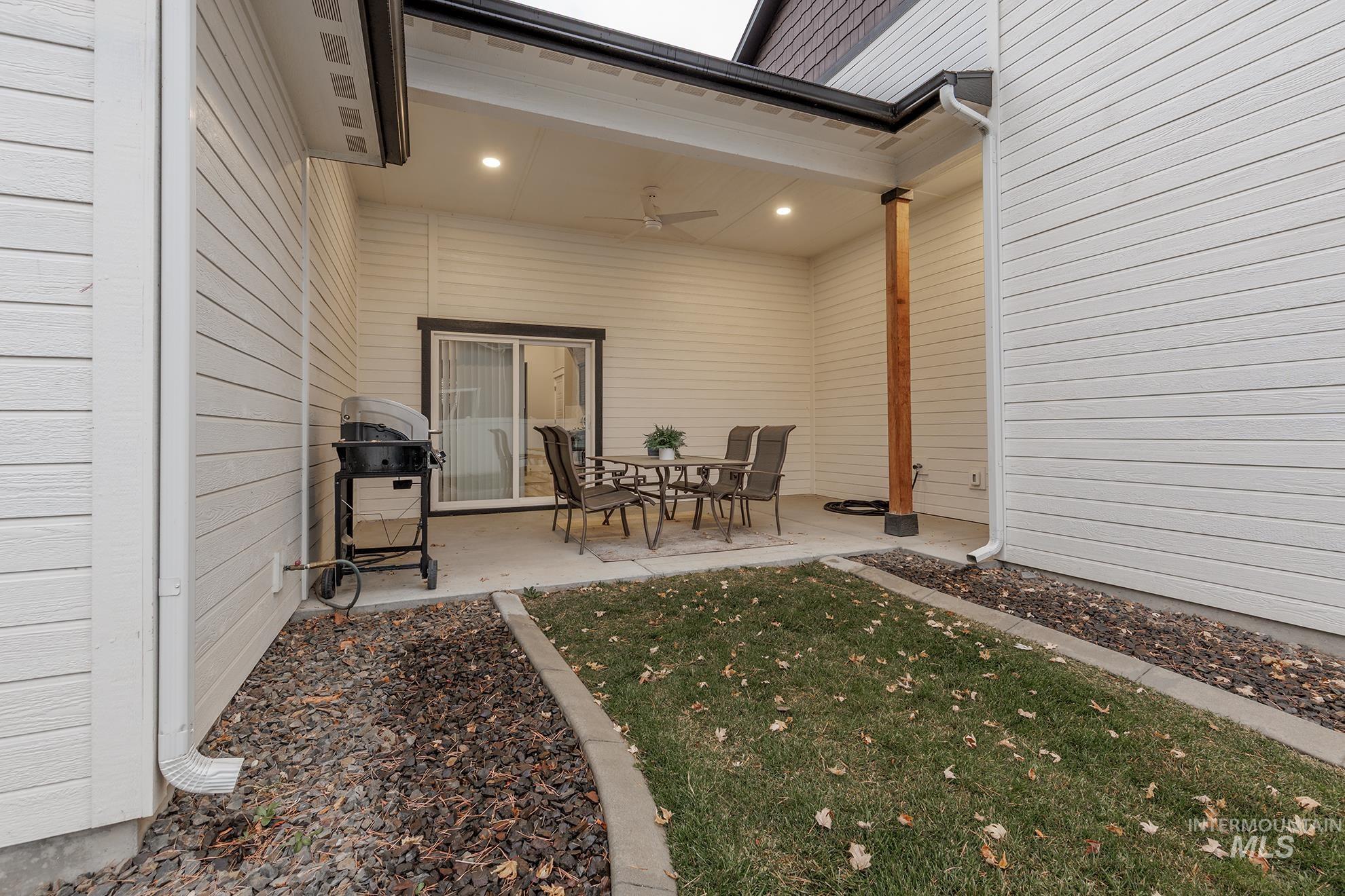 View of patio with grilling area and a ceiling fan