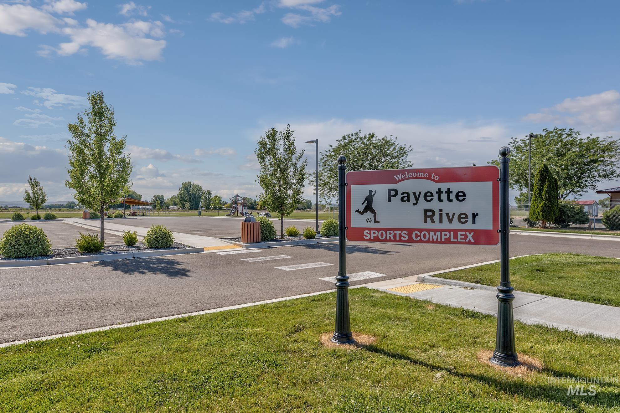 View of asphalt road featuring curbs and street lighting