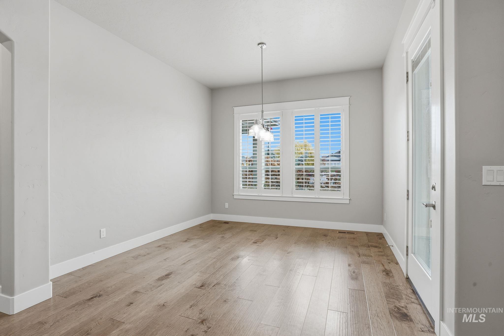 Unfurnished dining area with light wood-type flooring and a chandelier
