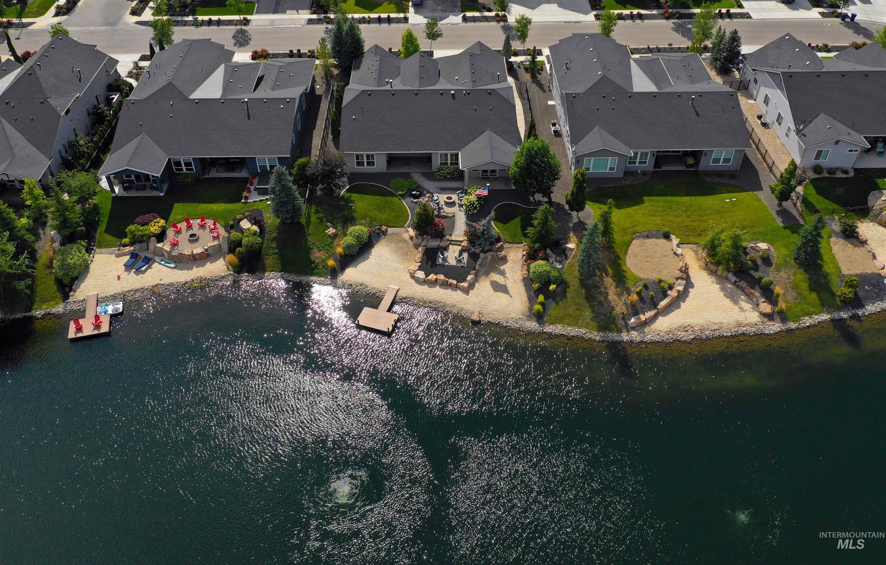 Aerial view of property and surrounding area featuring nearby suburban area and a nearby body of water