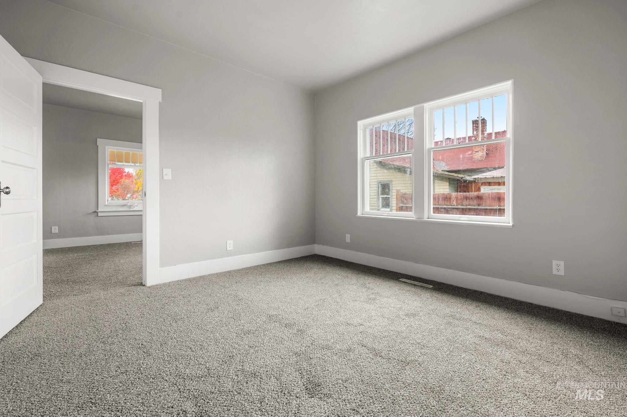 Carpeted empty room featuring baseboards