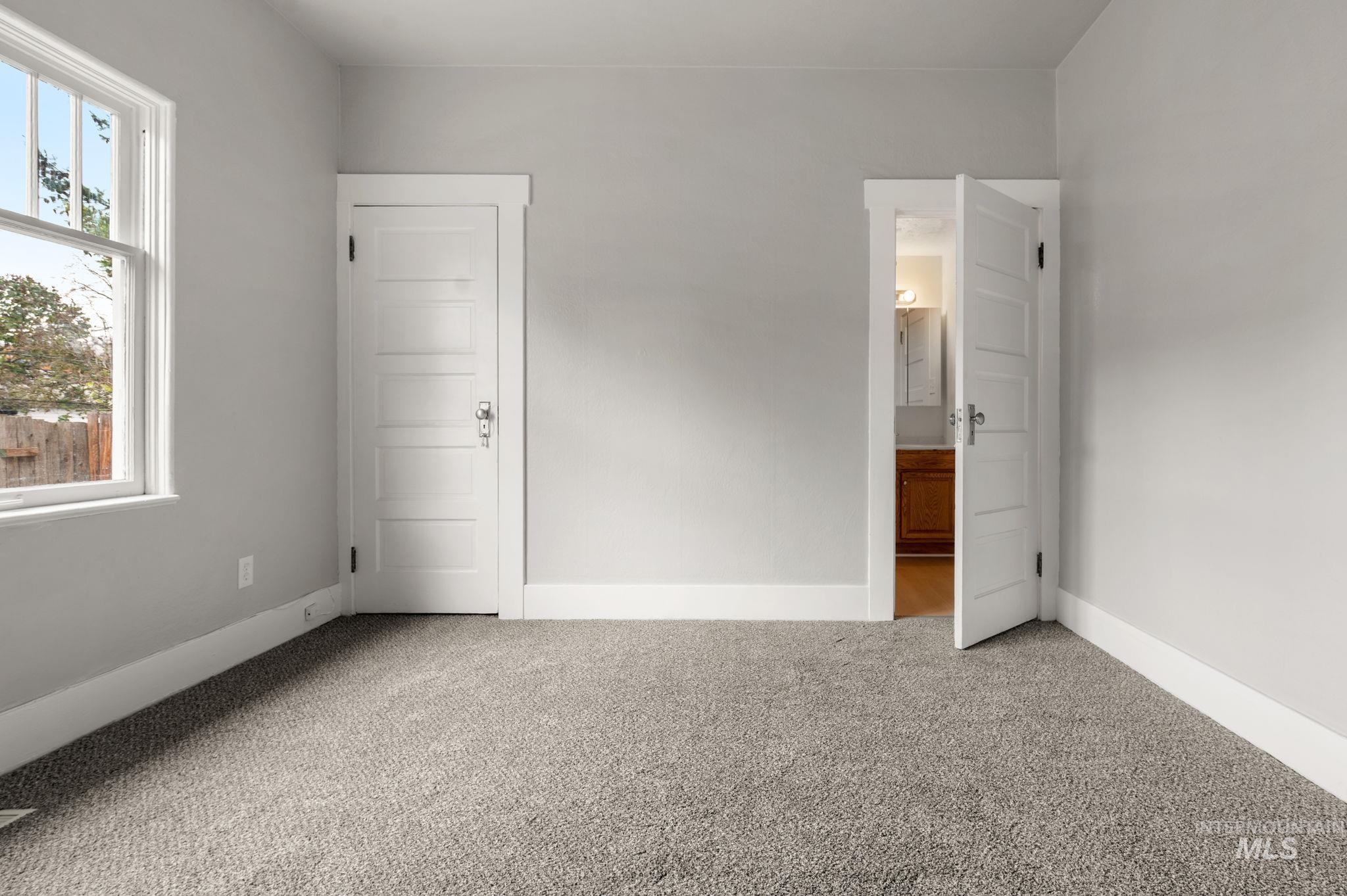 Unfurnished bedroom featuring carpet flooring and ensuite bathroom