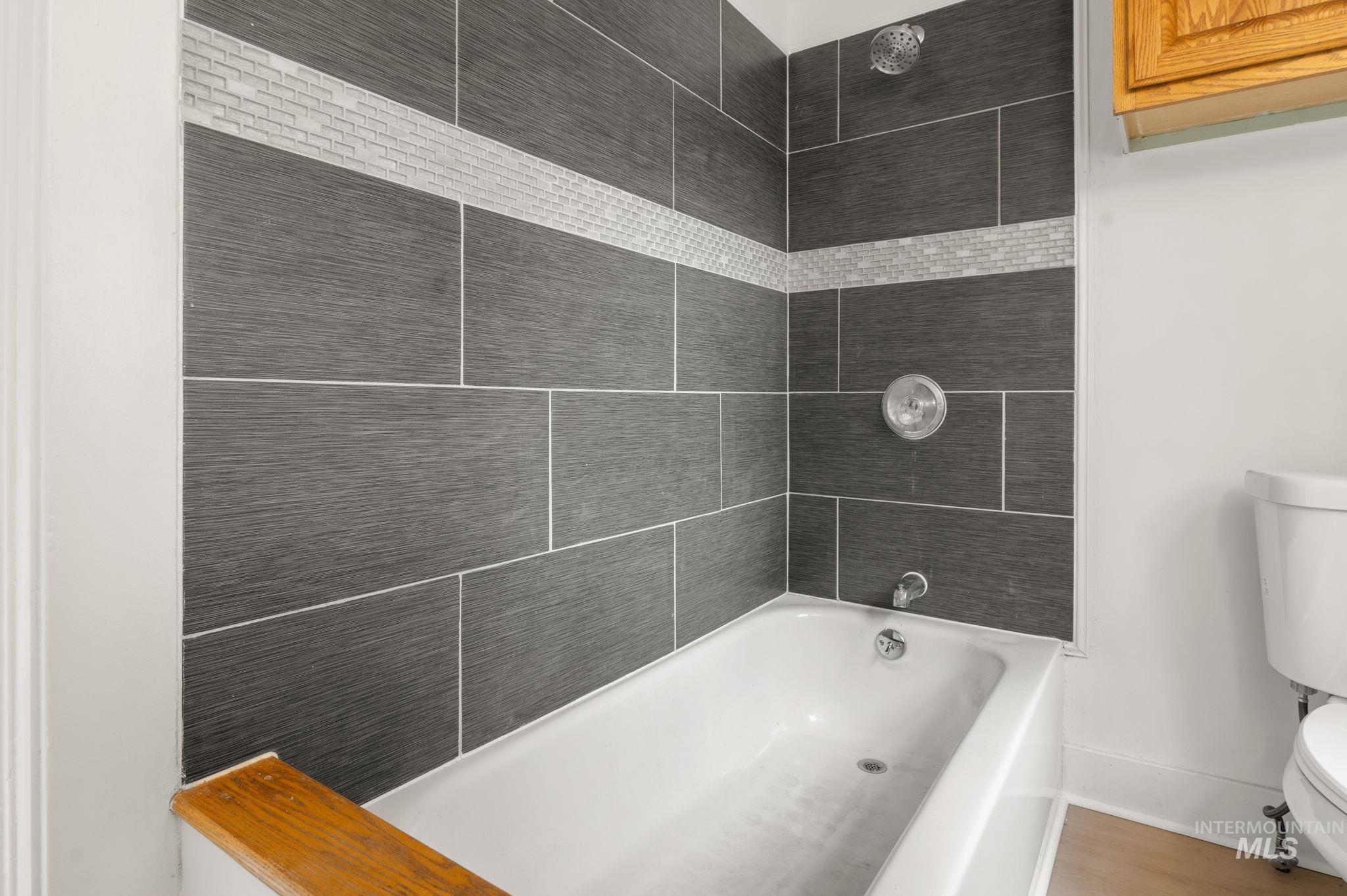 Bathroom featuring toilet and shower / bathtub combination