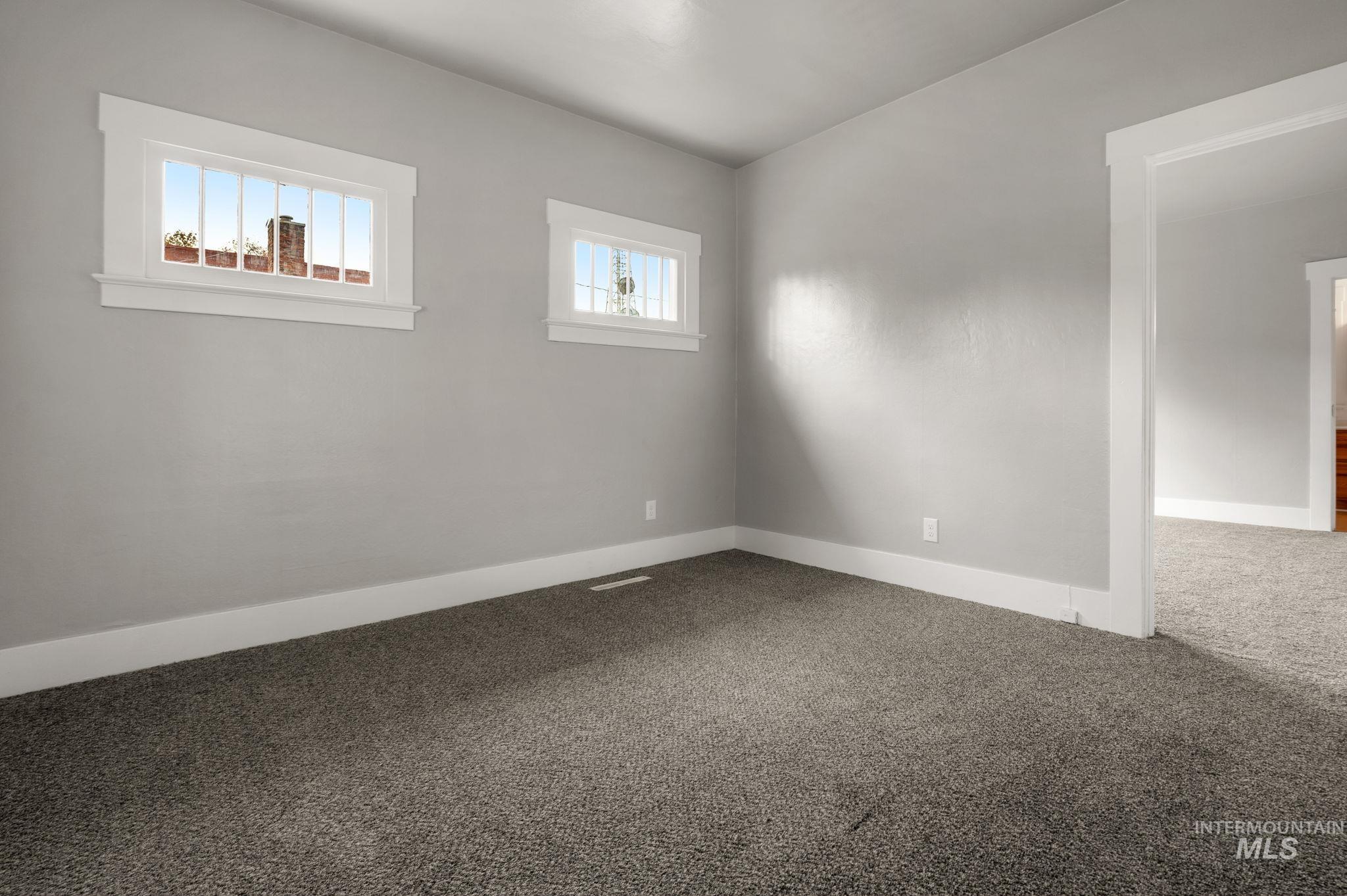 Empty room featuring carpet flooring and baseboards