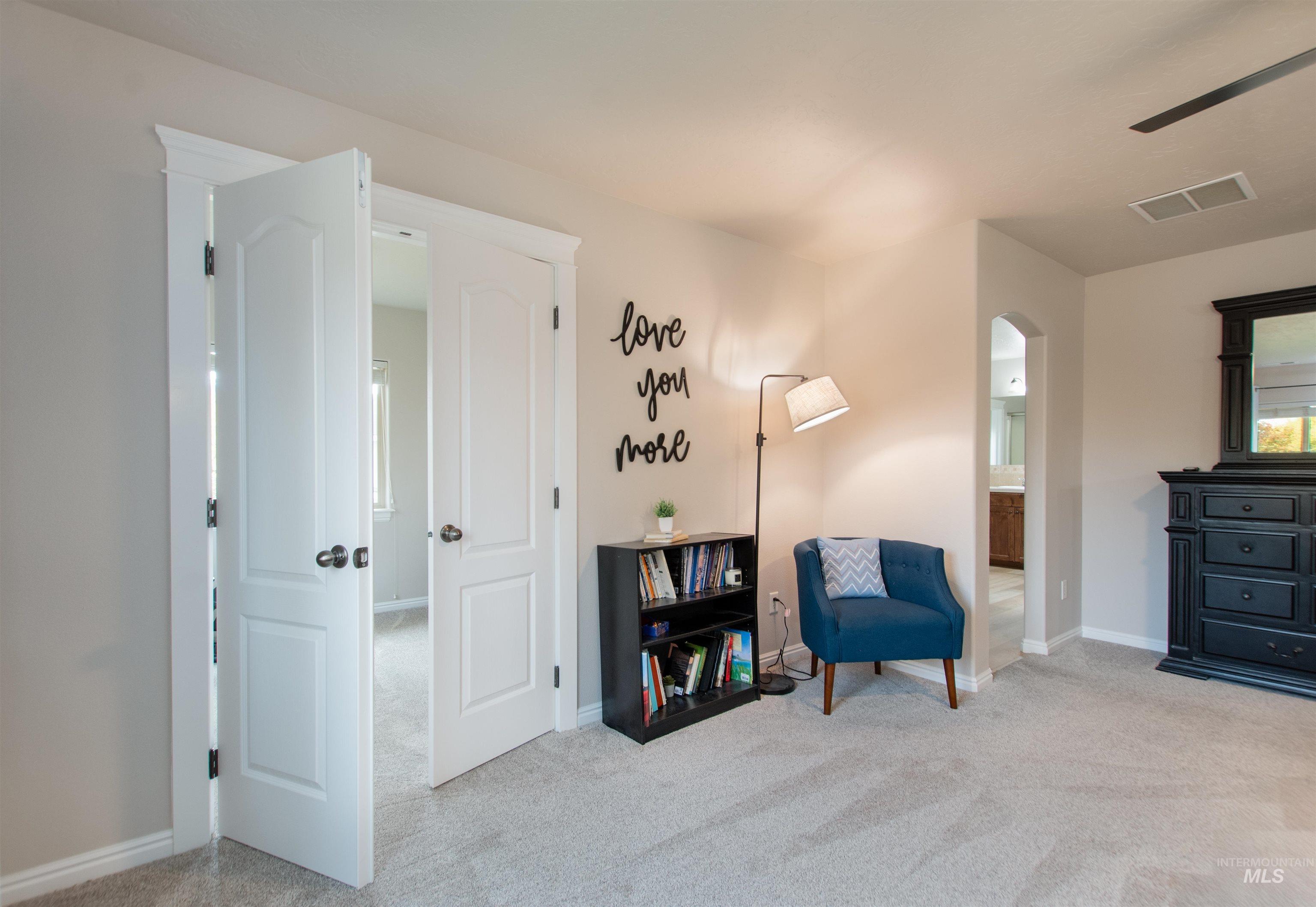 Sitting room with light colored carpet and arched walkways