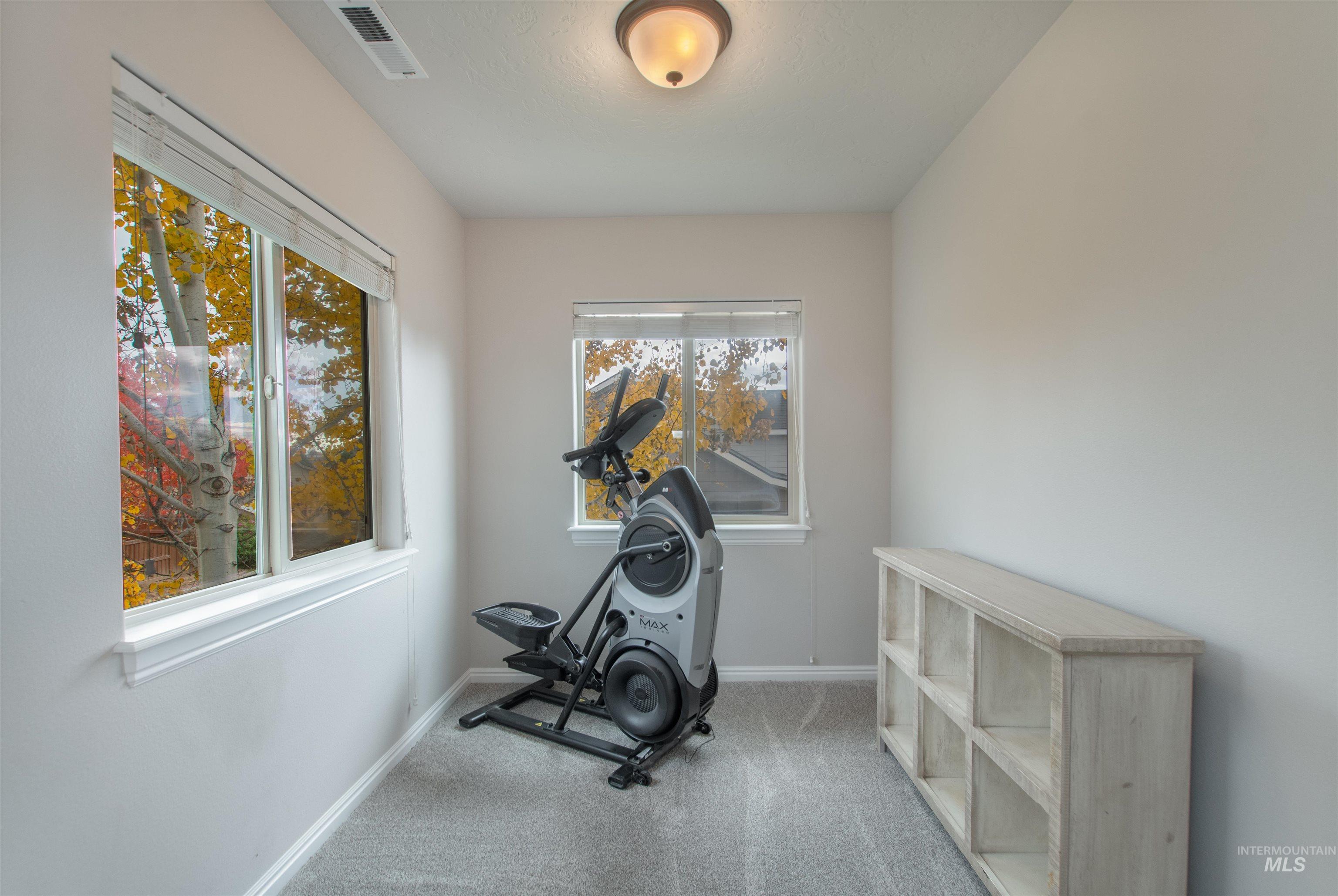 Workout room featuring carpet and baseboards