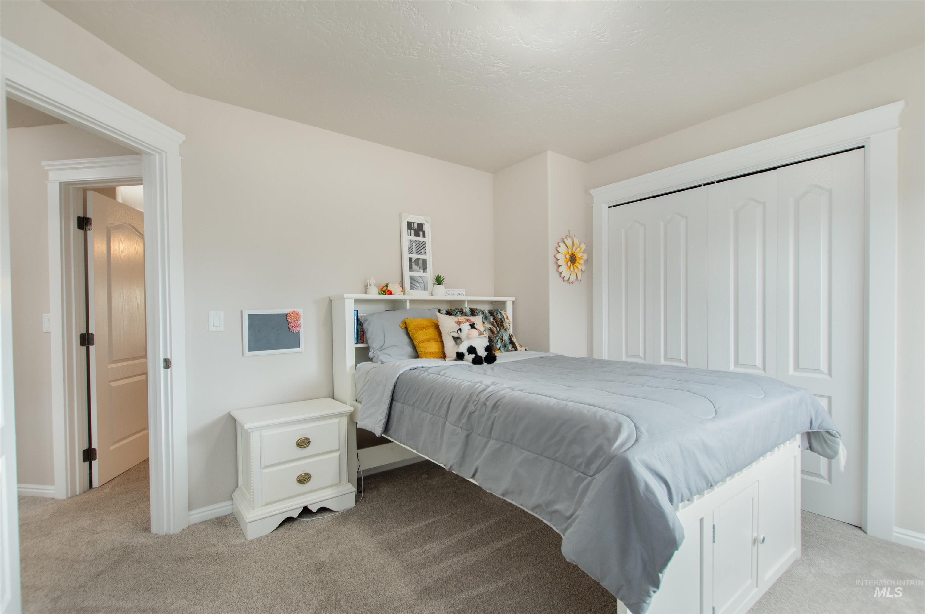 Bedroom featuring light colored carpet and a closet