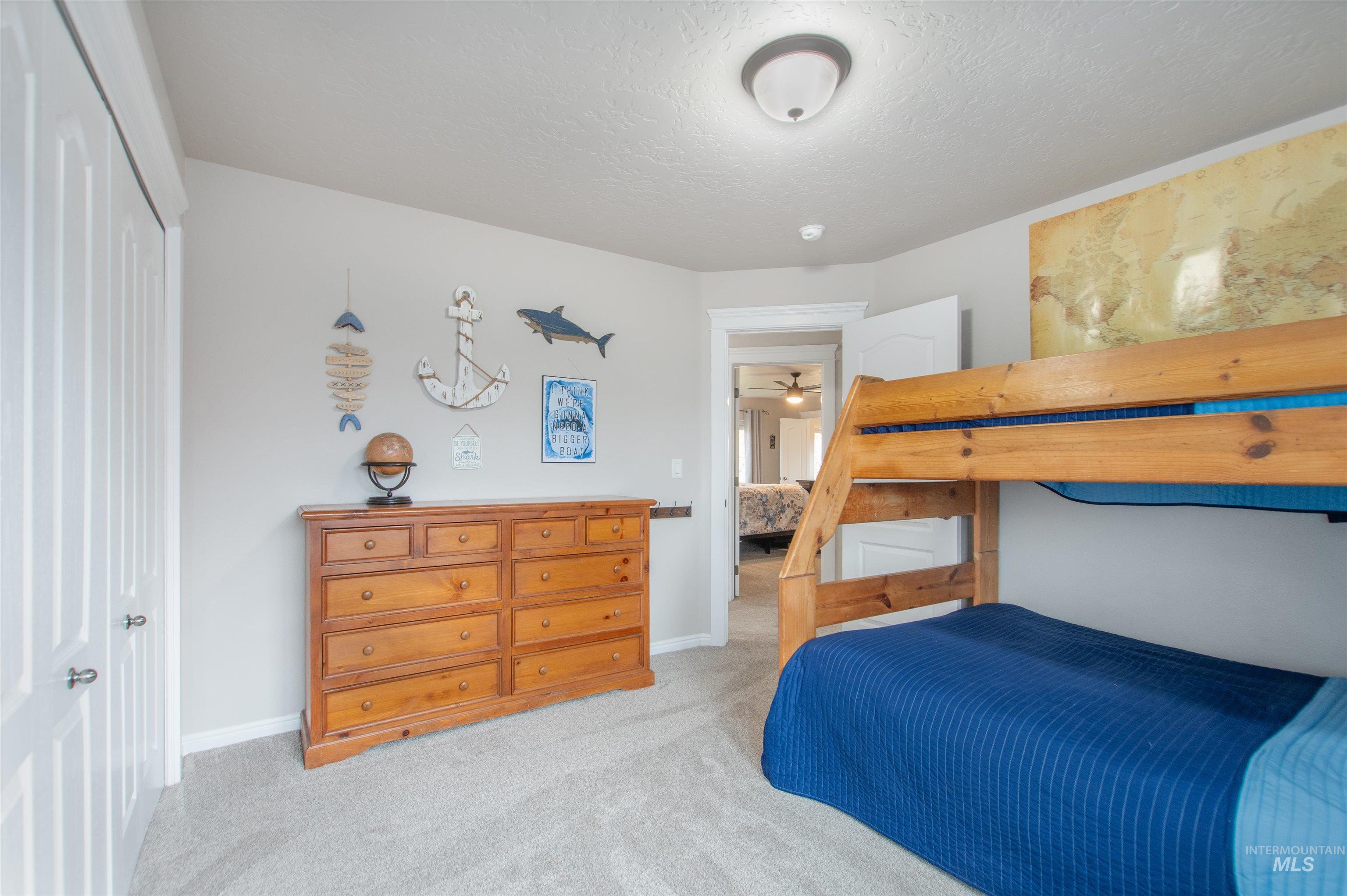 Carpeted bedroom with a textured ceiling and a closet