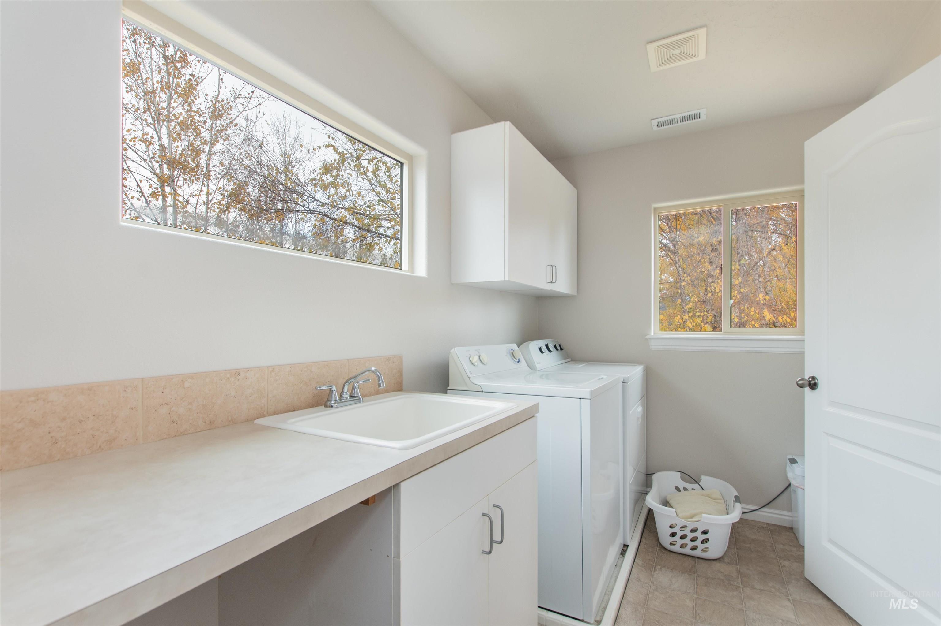 Washroom with cabinet space and washer and dryer