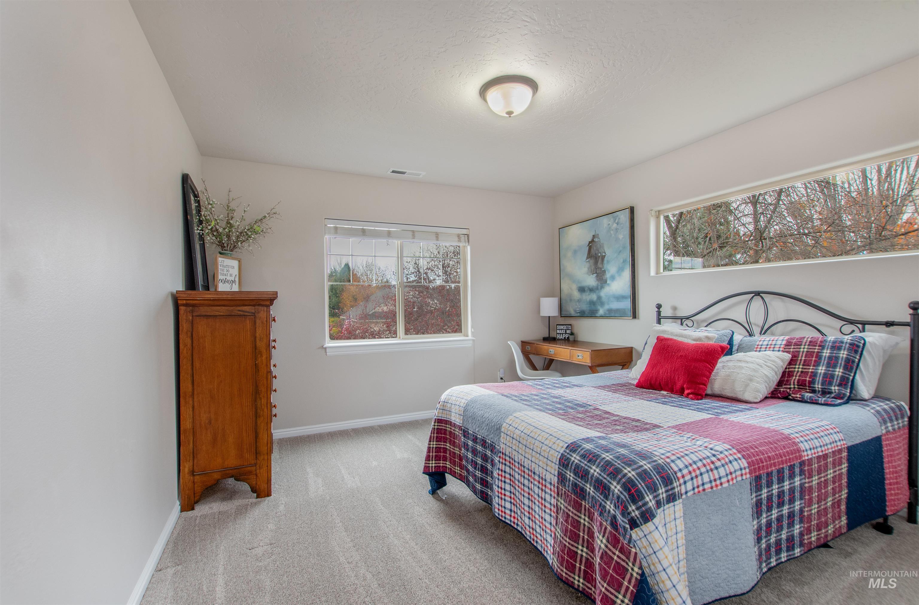 Bedroom featuring light carpet and a textured ceiling