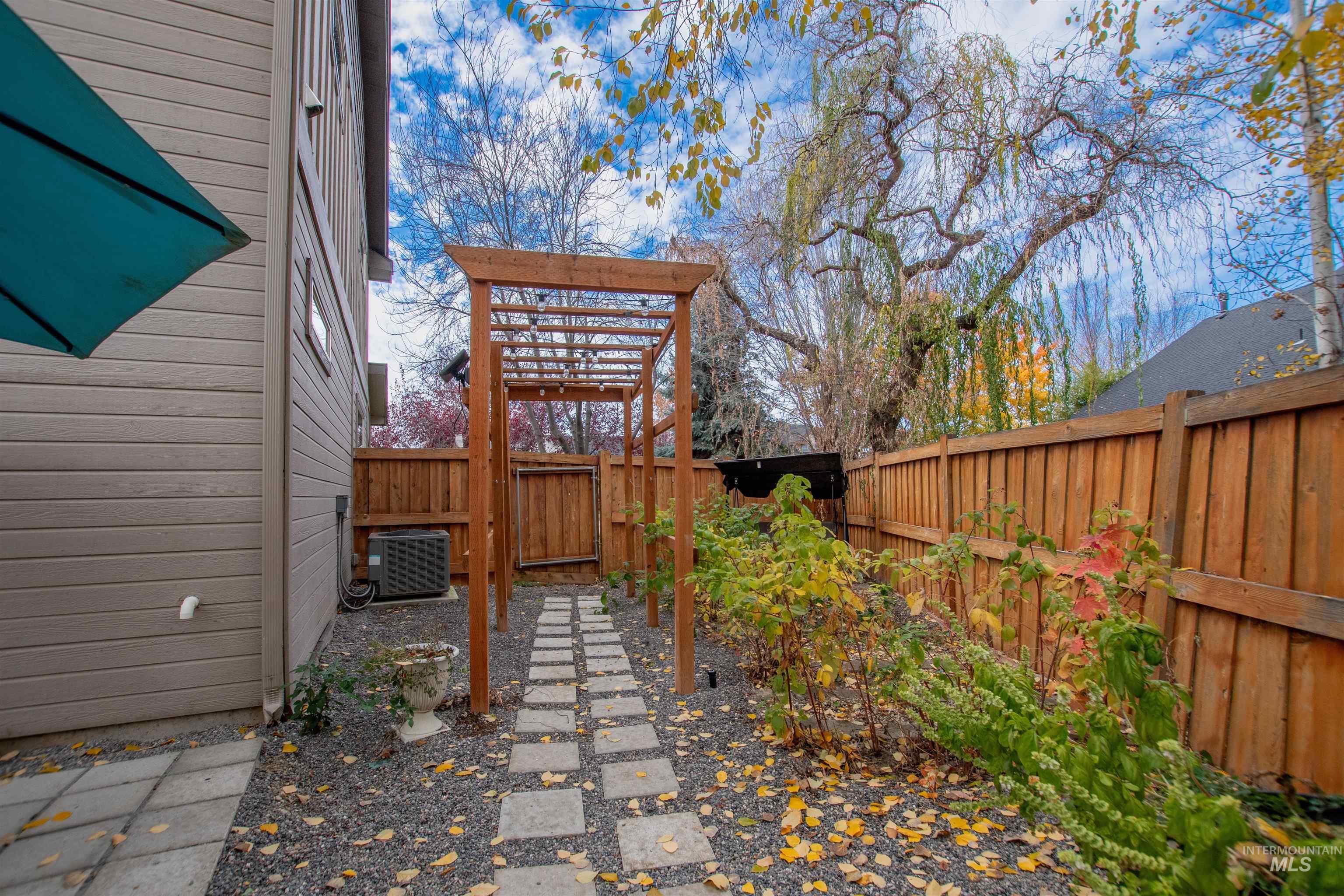 Fenced backyard featuring a pergola