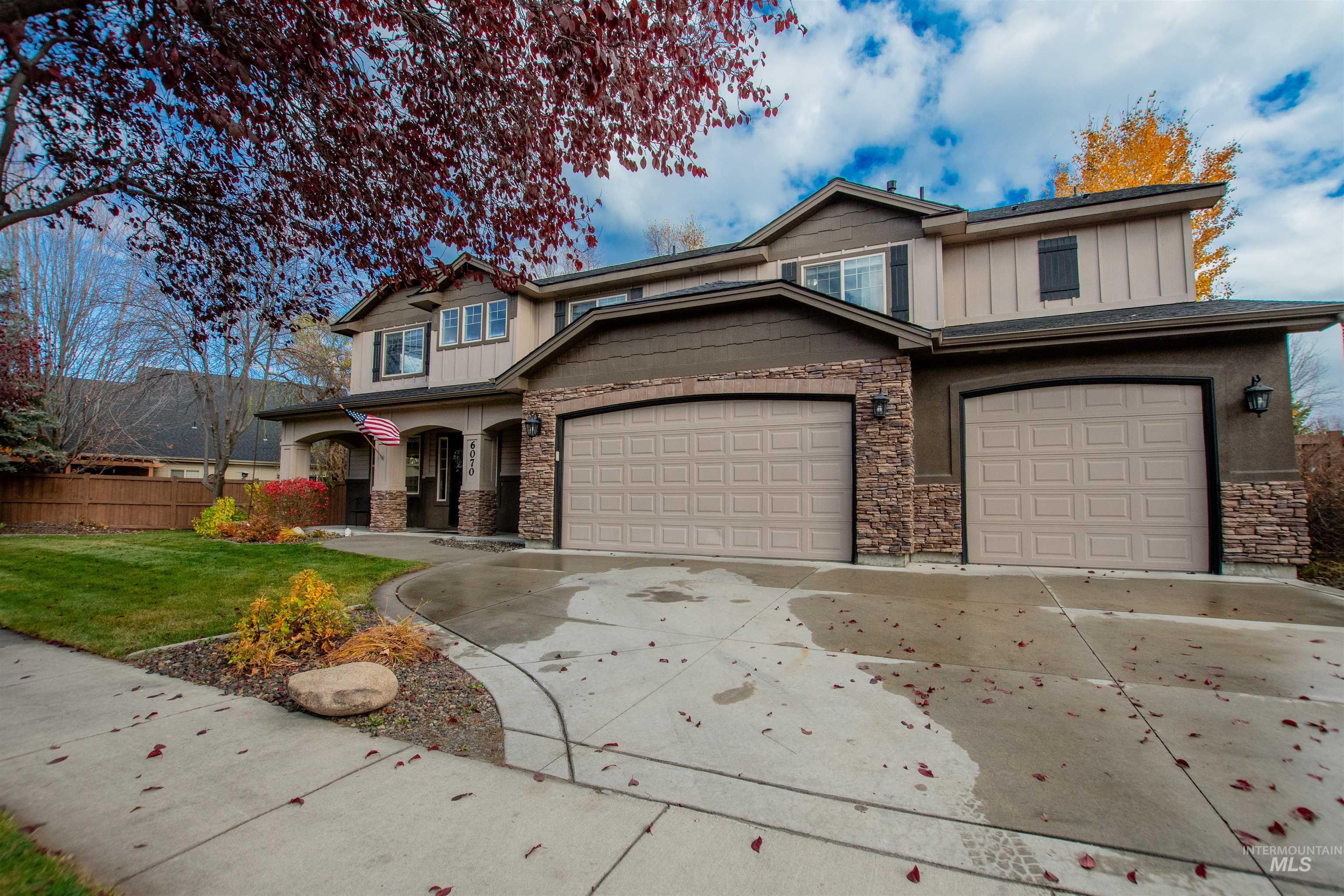 Craftsman inspired home featuring board and batten siding, driveway, a porch, and an attached garage