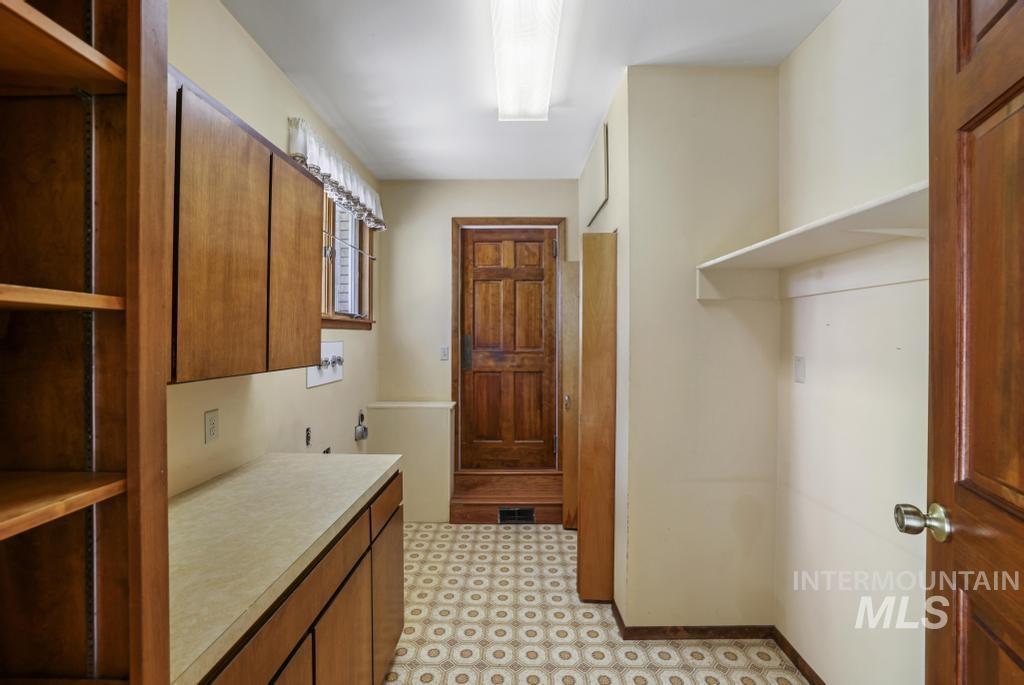 Laundry area with cabinet space, light flooring, and hookup for a washing machine