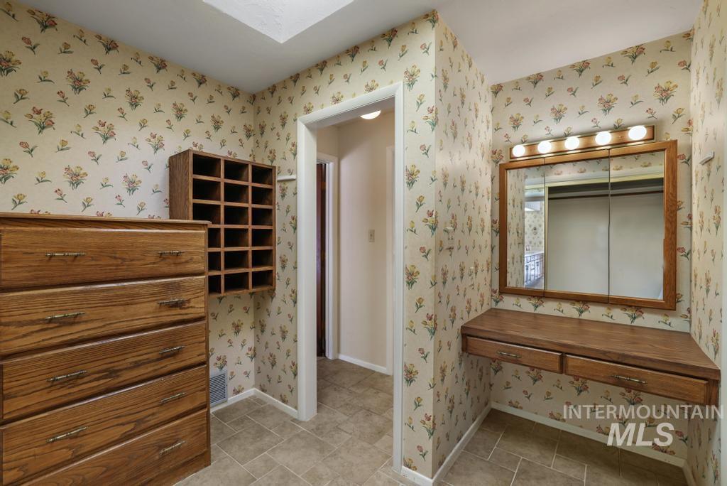 Bathroom with a skylight and wallpapered walls