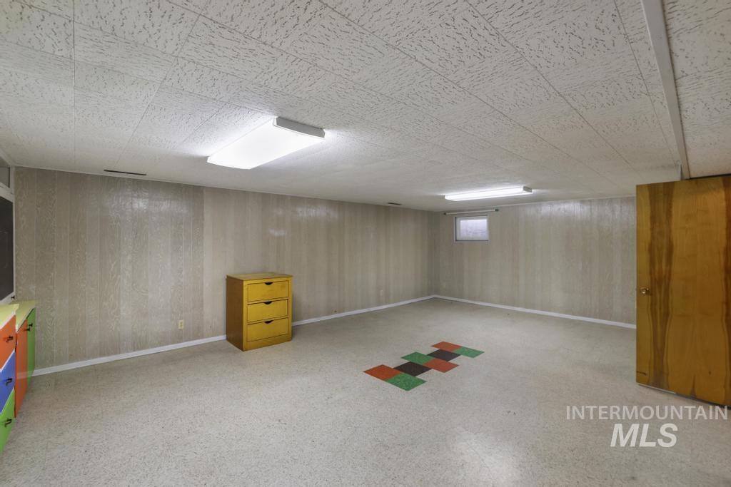 Basement with baseboards and wooden walls