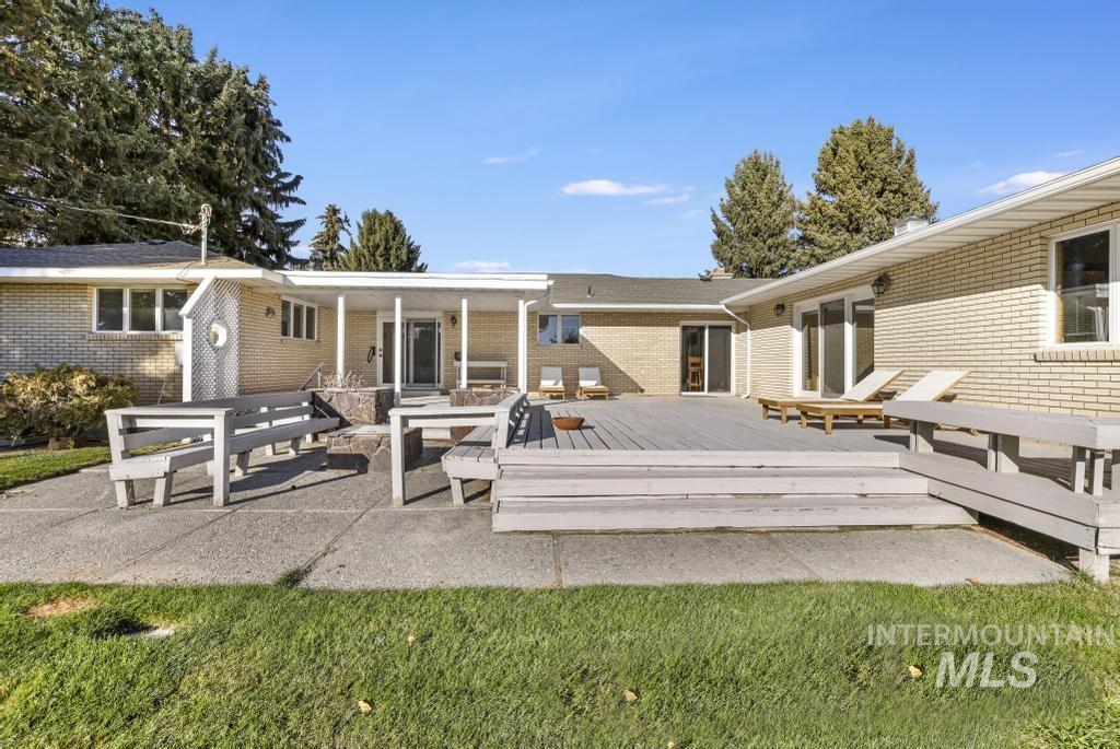 Rear view of property with a patio, a deck, and brick siding