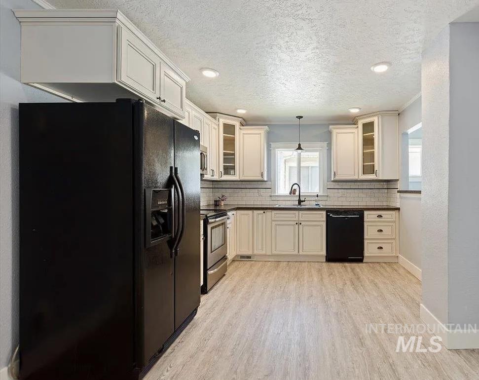 Kitchen featuring black appliances, glass insert cabinets, decorative light fixtures, backsplash, and recessed lighting