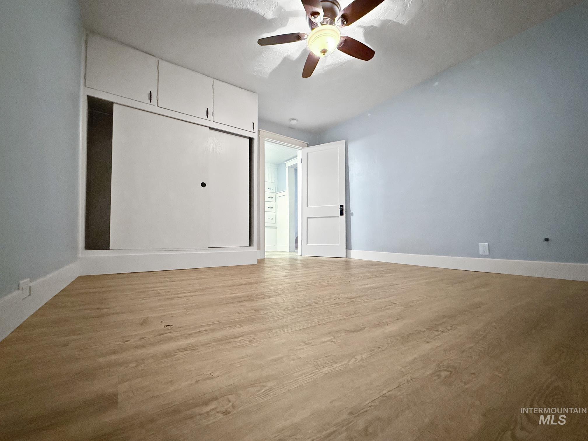 Unfurnished bedroom featuring light wood-type flooring and ceiling fan