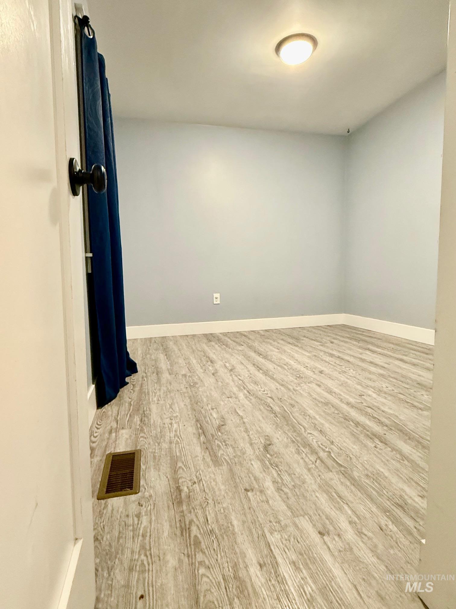 Unfurnished room featuring baseboards and light wood-style floors
