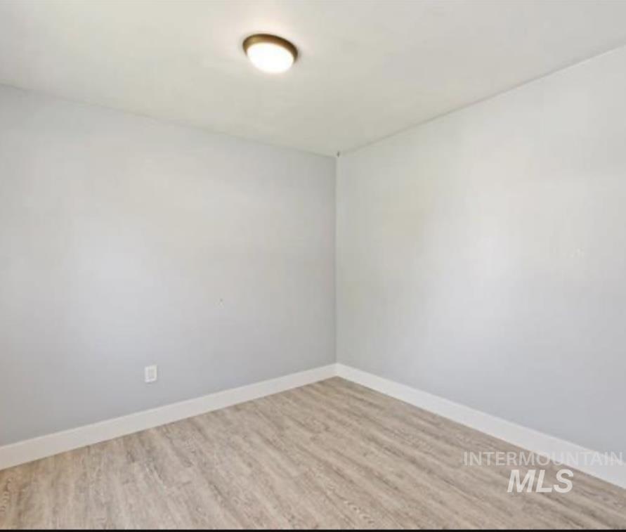 Empty room featuring light wood finished floors and baseboards