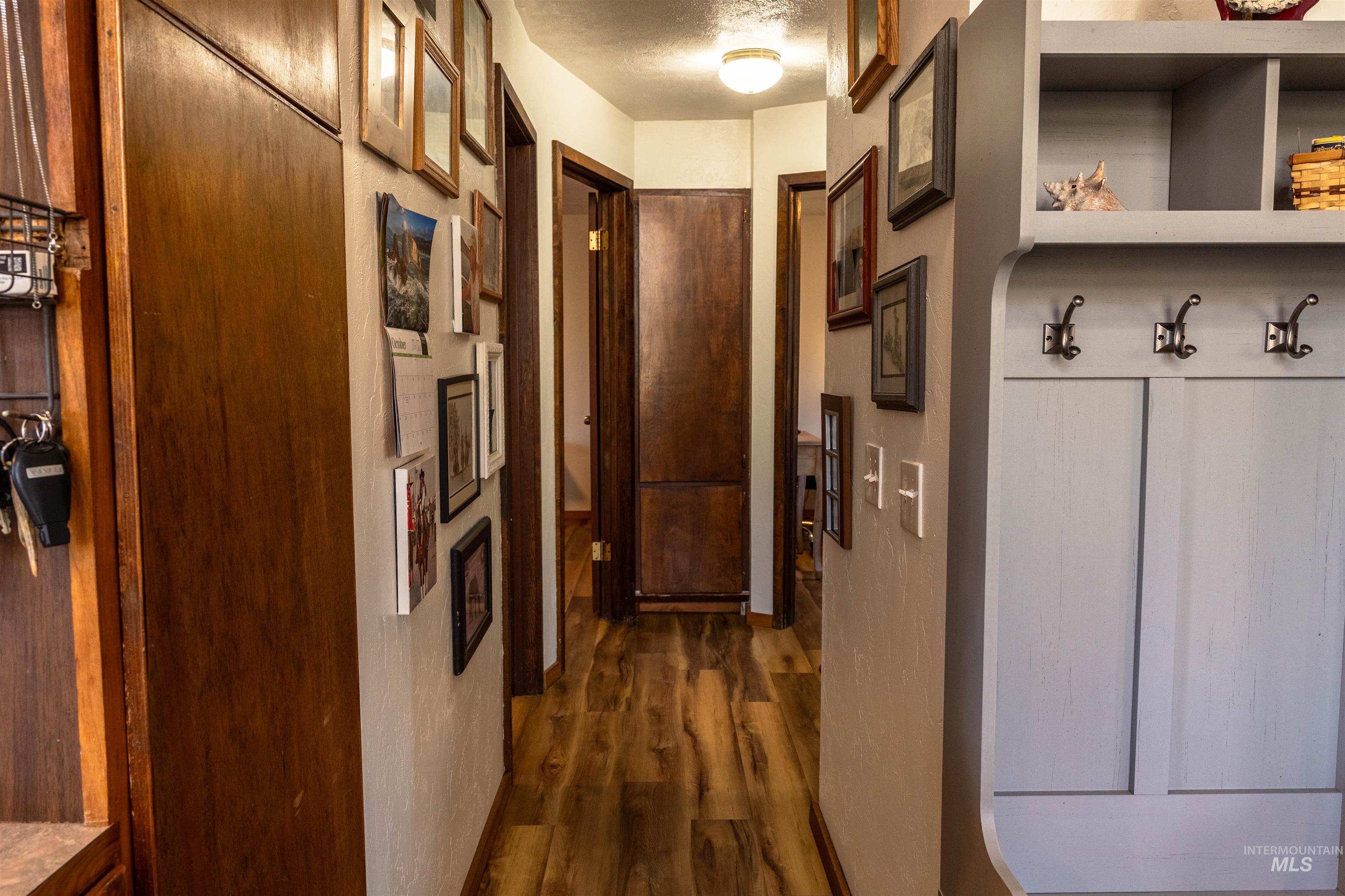 Corridor featuring dark wood finished floors and a textured ceiling