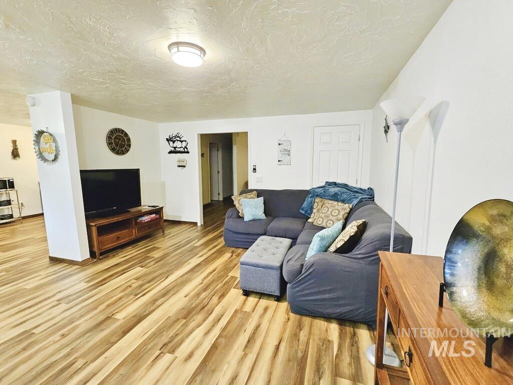 Living room with light wood-type flooring and a textured ceiling