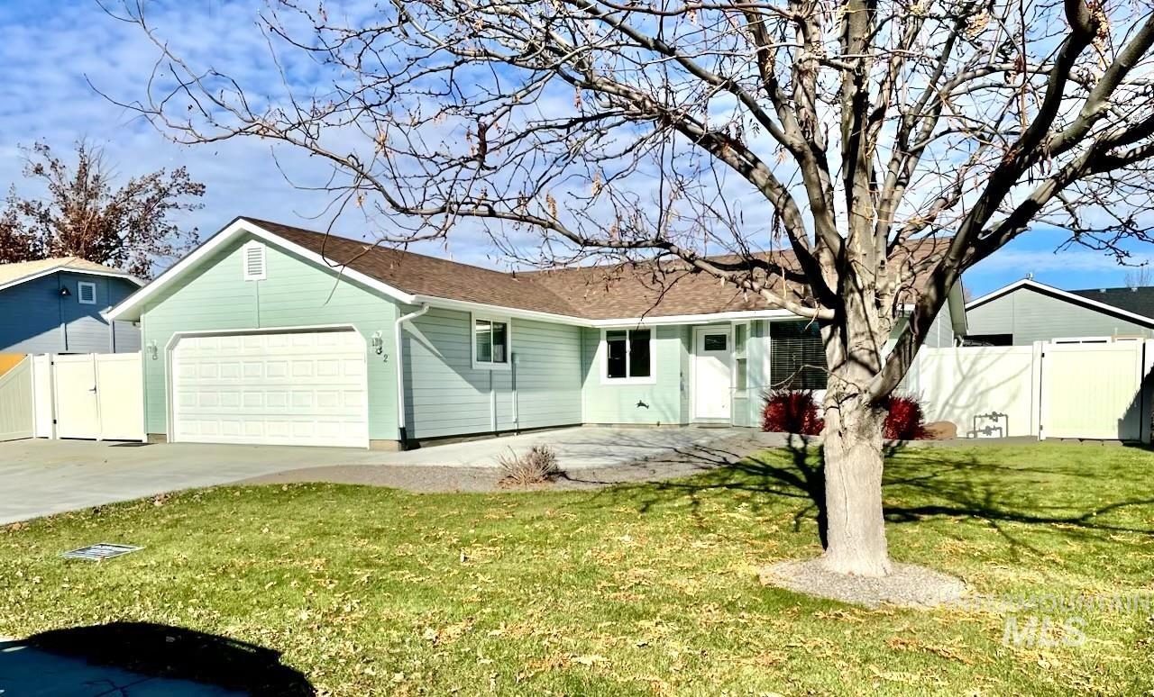 Ranch-style home with driveway, a garage, a gate, a patio area, and a shingled roof