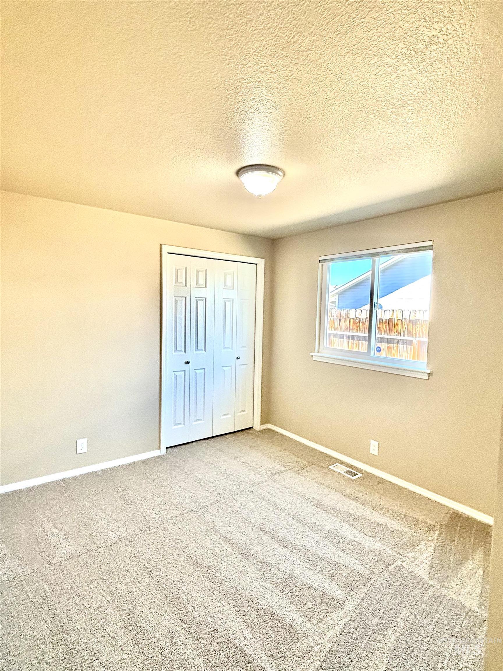 Unfurnished bedroom featuring carpet, a closet, and a textured ceiling