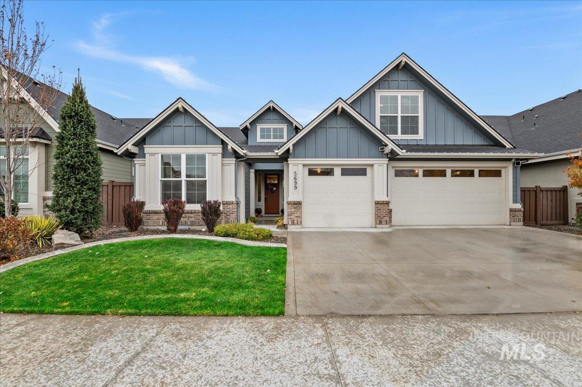 Craftsman house featuring board and batten siding, brick siding, concrete driveway, and a garage