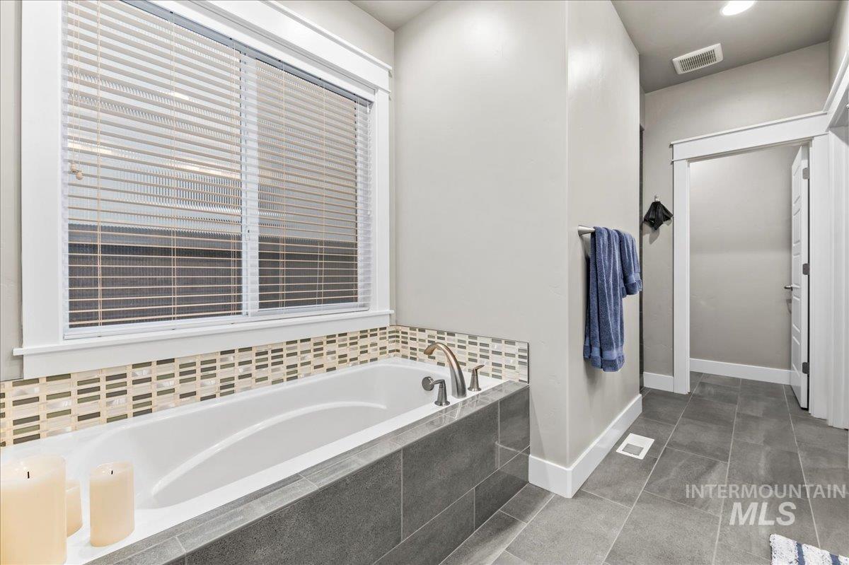 Bathroom with a bath, tile patterned flooring, and recessed lighting