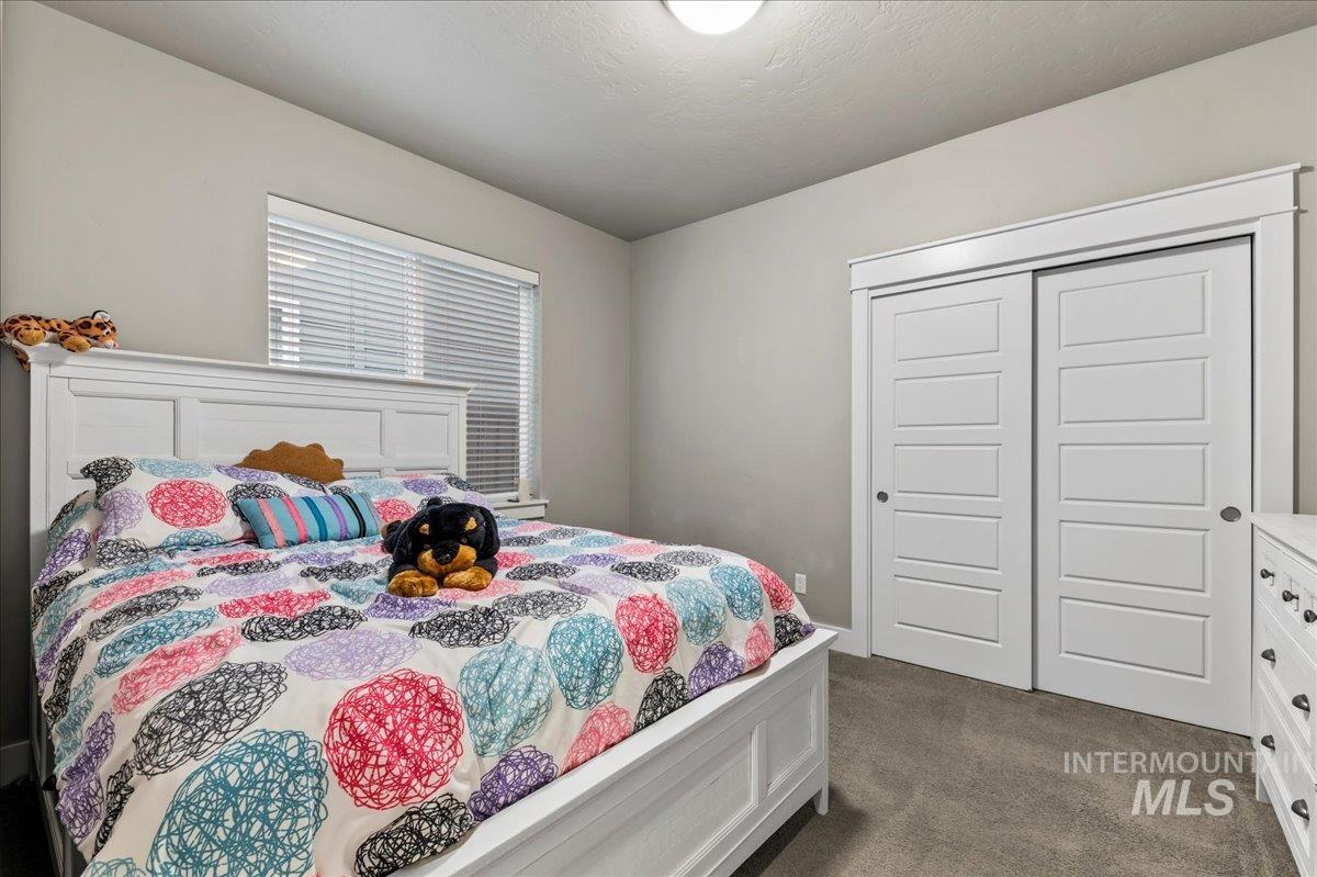 Bedroom featuring dark carpet and a closet