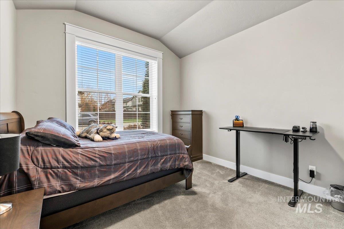 Bedroom featuring light colored carpet and lofted ceiling