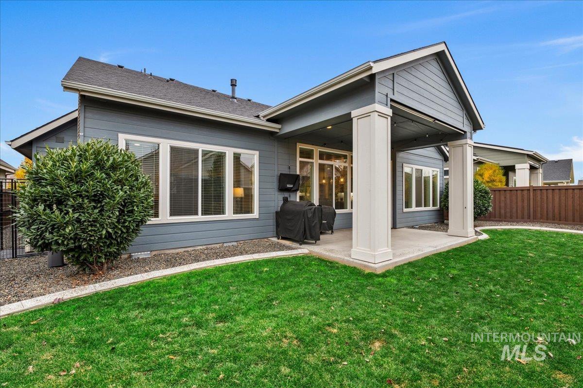 Rear view of property with a fenced backyard and a patio area