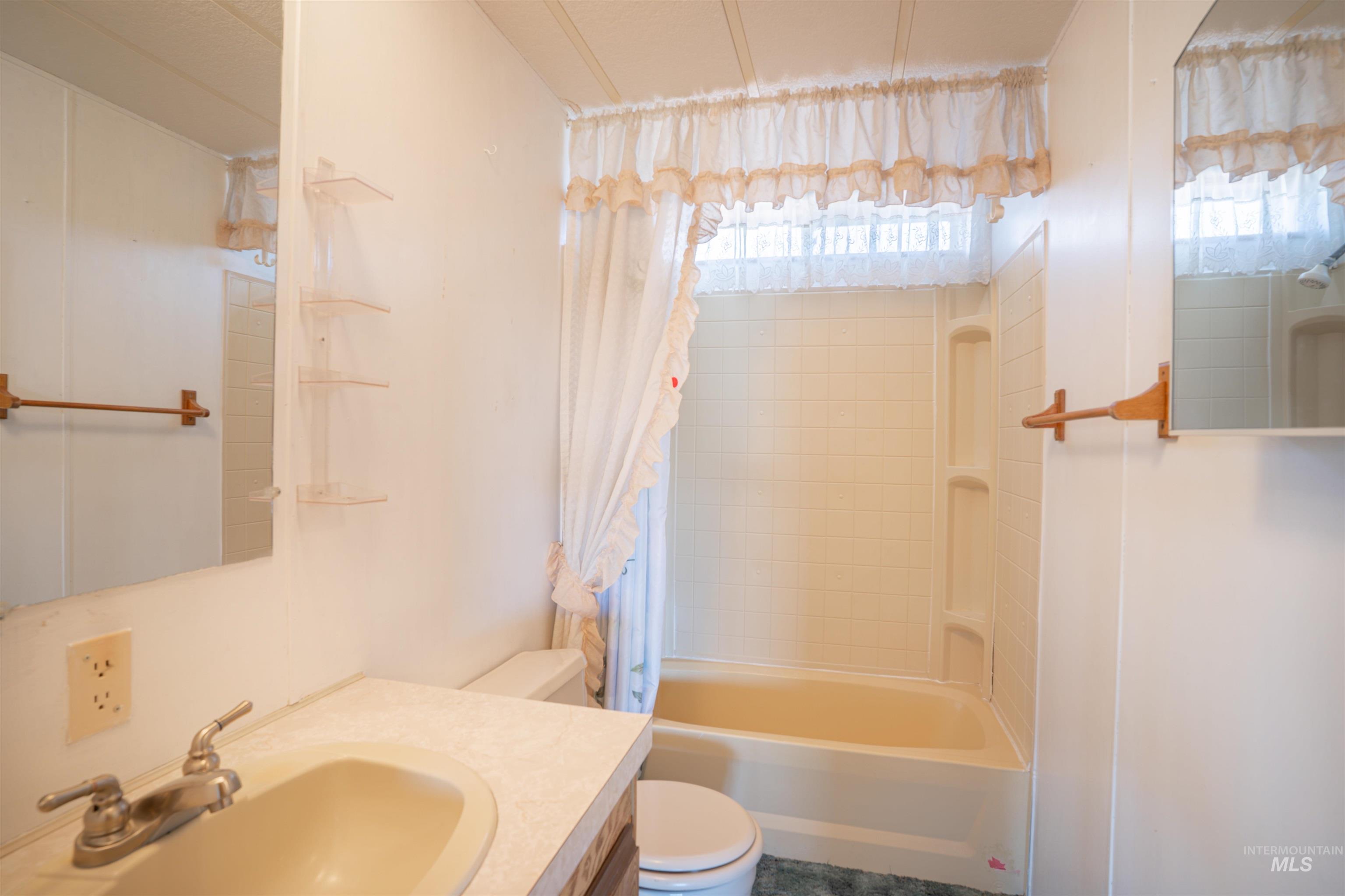 Bathroom with shower / bath combo with shower curtain and vanity