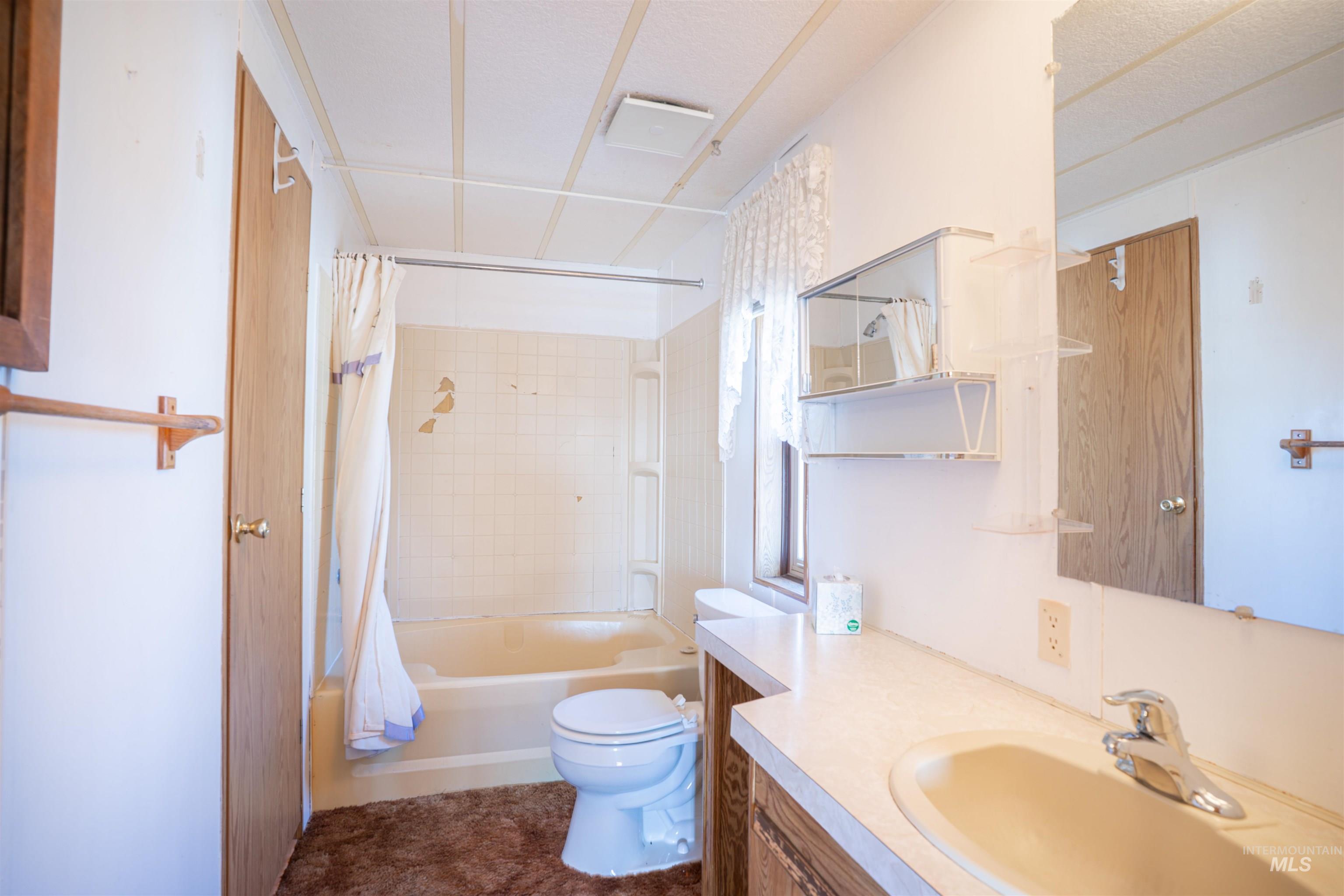 Bathroom with shower / bath combination with curtain and vanity