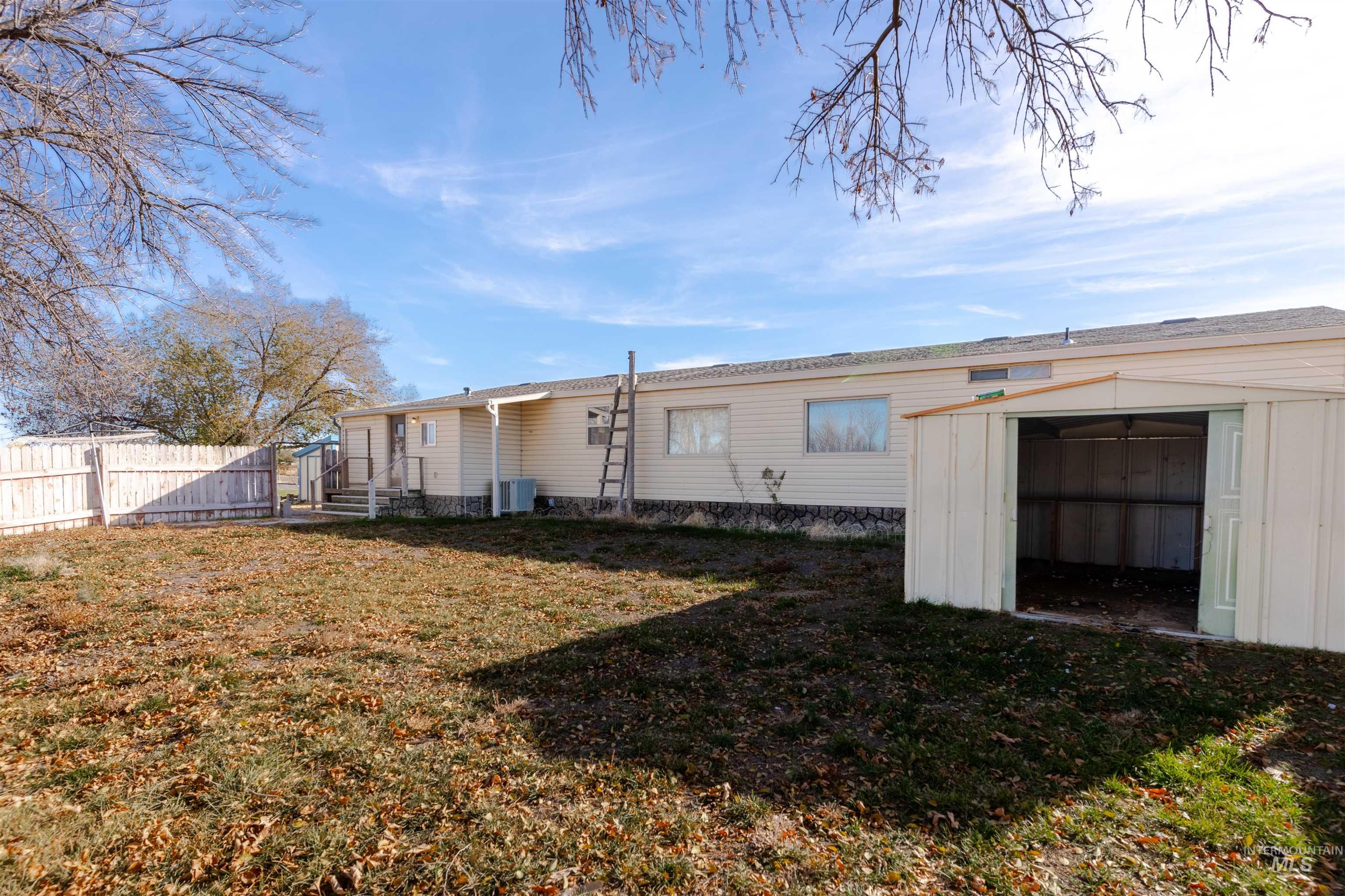 Back of property featuring a storage unit