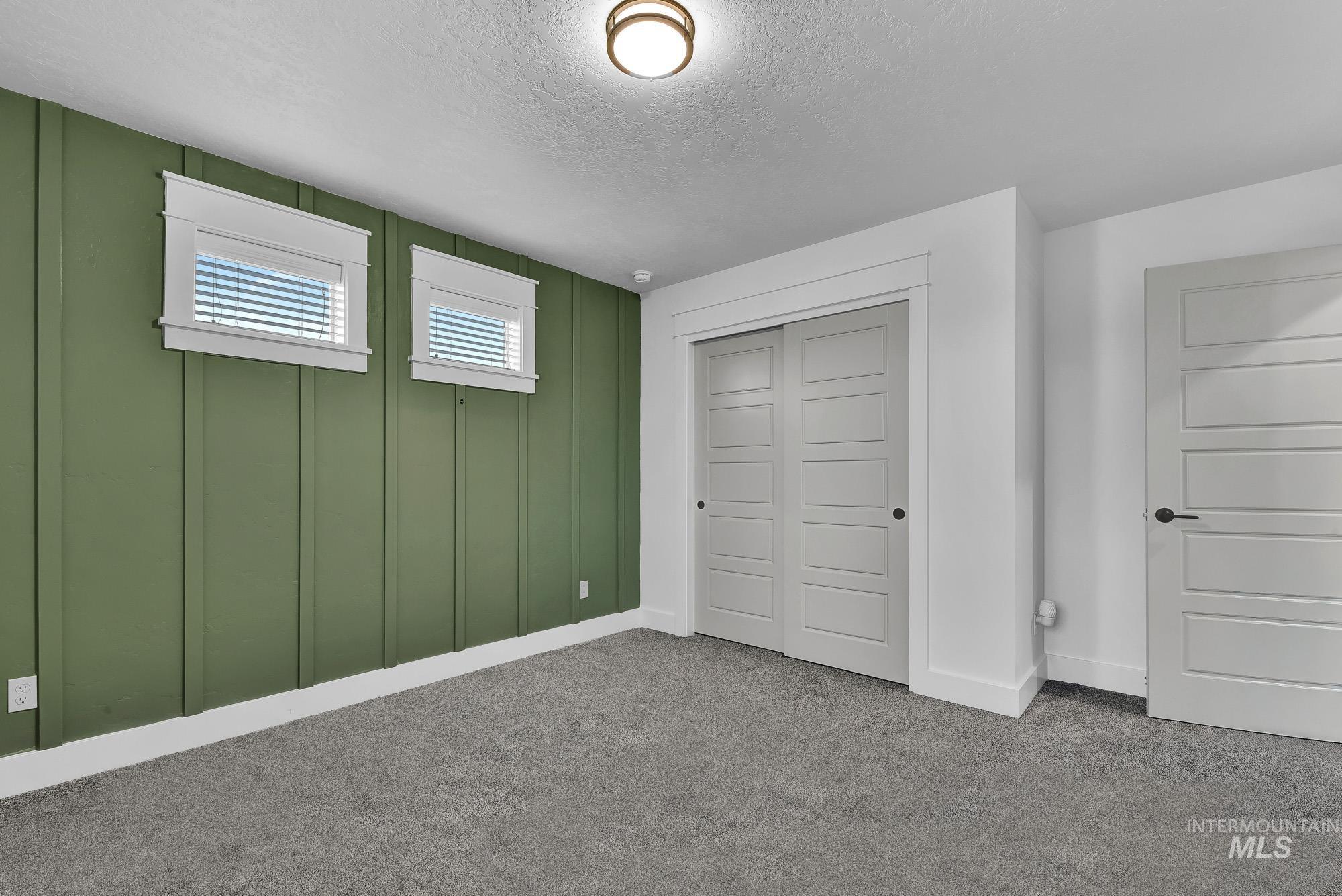 Unfurnished bedroom featuring a textured ceiling, a closet, and carpet