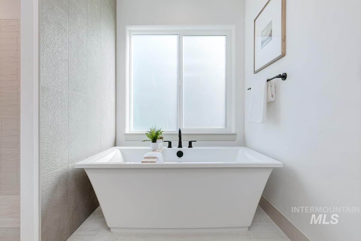 Full bathroom with plenty of natural light and a freestanding bath