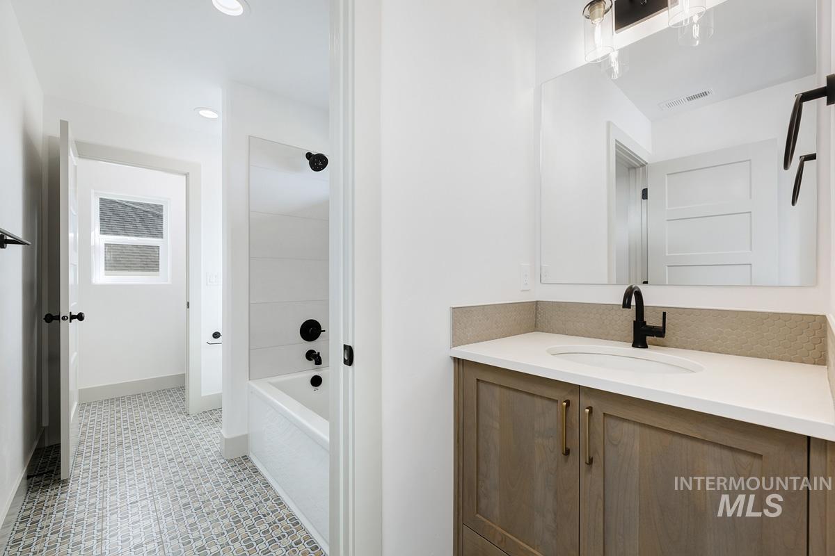 Bathroom featuring vanity, recessed lighting, and shower / washtub combination